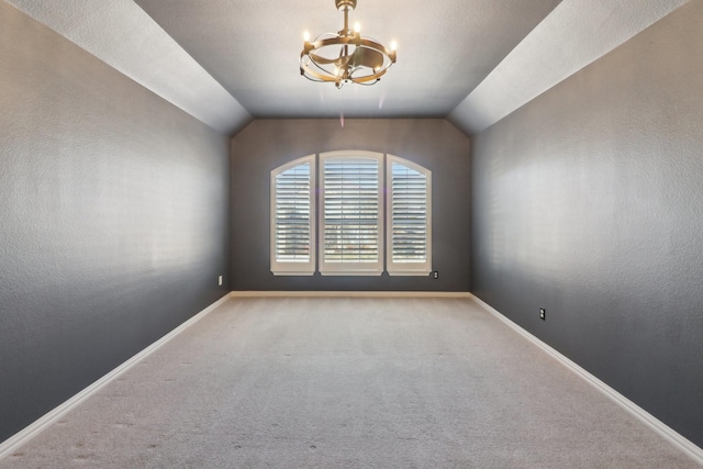 unfurnished room with vaulted ceiling, light carpet, and a notable chandelier