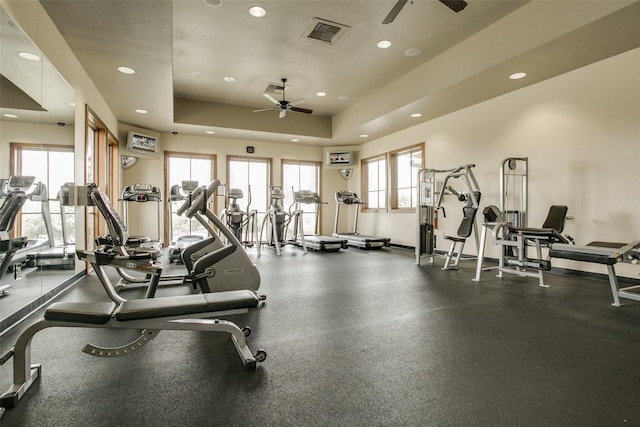 workout area with ceiling fan and a raised ceiling