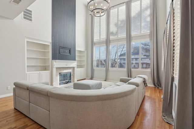 living room featuring hardwood / wood-style flooring, a chandelier, and a high end fireplace