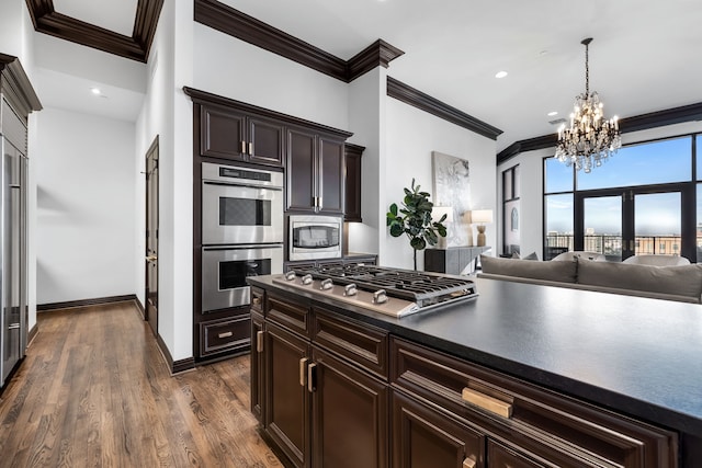 kitchen with dark hardwood / wood-style floors, crown molding, an inviting chandelier, dark brown cabinetry, and stainless steel appliances