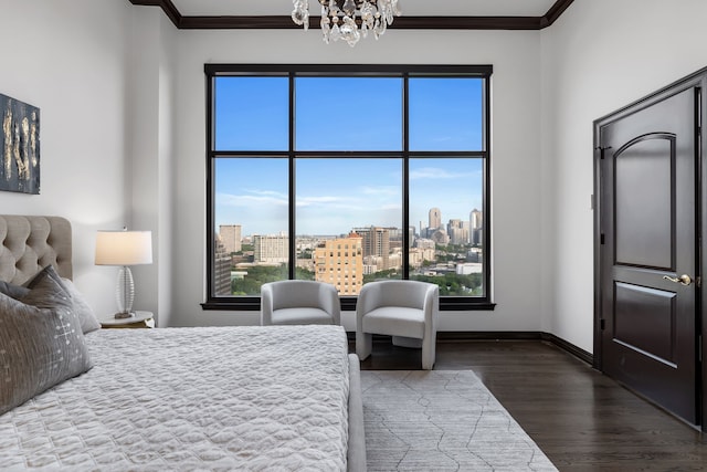 bedroom featuring dark hardwood / wood-style flooring, crown molding, and a notable chandelier