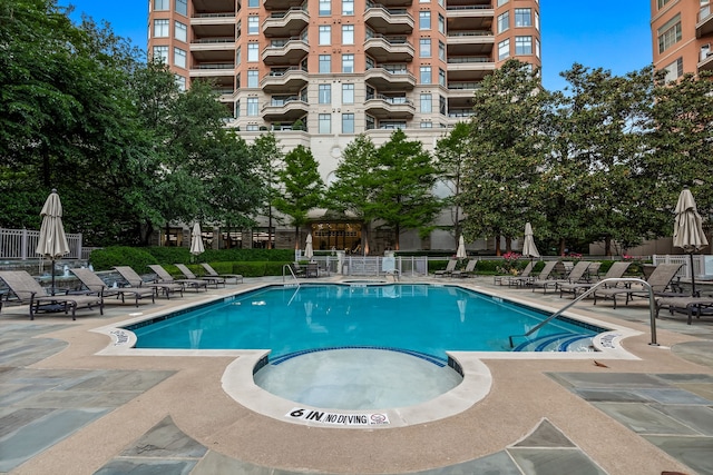 view of swimming pool with a hot tub and a patio