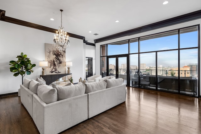 living room with dark hardwood / wood-style floors, crown molding, and an inviting chandelier