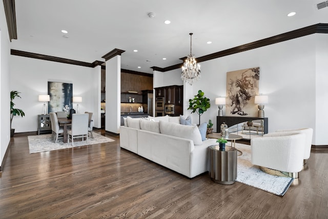 living room with dark wood-type flooring, crown molding, and a notable chandelier