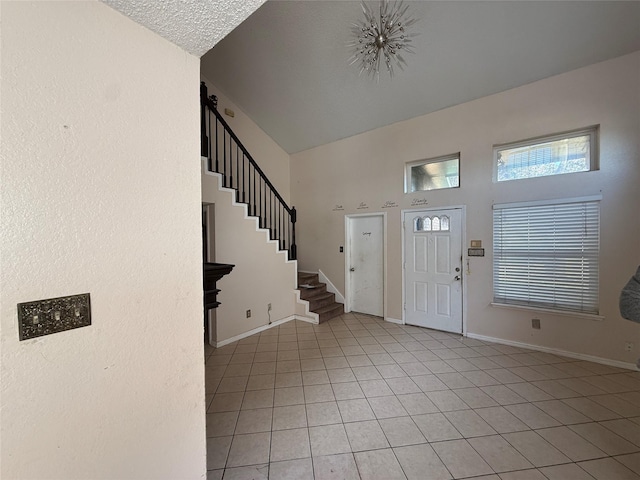 tiled entryway featuring a towering ceiling and a textured ceiling