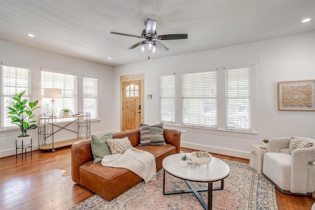 living room with ceiling fan, a wealth of natural light, and light hardwood / wood-style floors