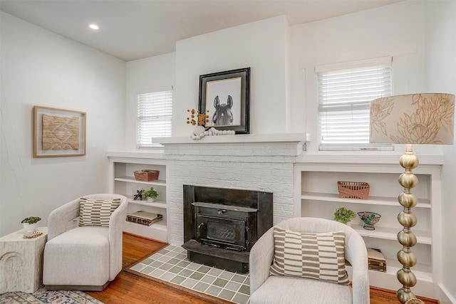 living area with a wood stove and wood-type flooring