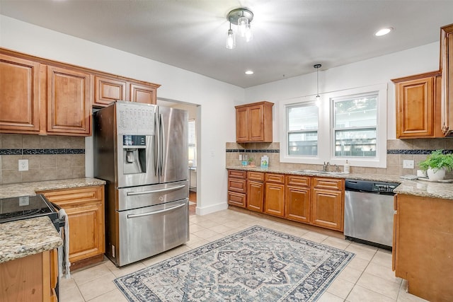 kitchen with light tile patterned floors, appliances with stainless steel finishes, and light stone countertops