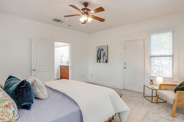 carpeted bedroom featuring ceiling fan and ensuite bath