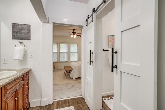 bathroom featuring ceiling fan, hardwood / wood-style floors, and vanity