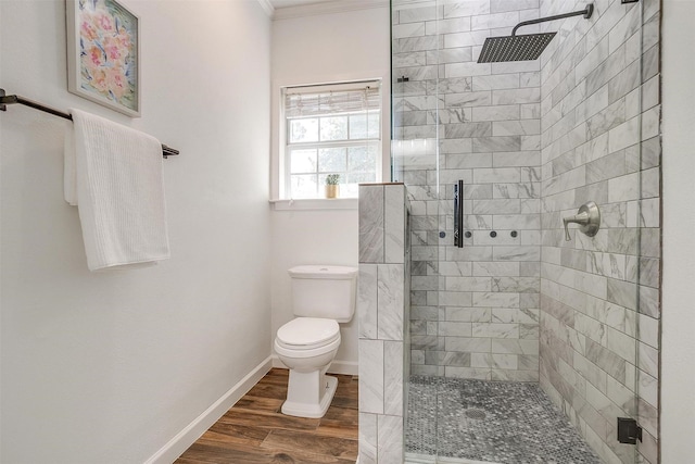 bathroom with toilet, ornamental molding, hardwood / wood-style flooring, and an enclosed shower