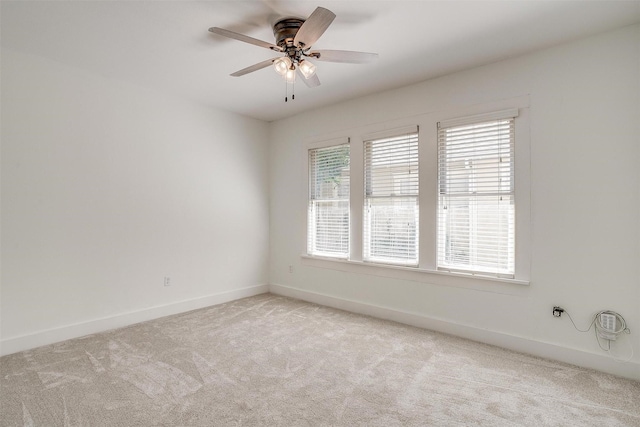 spare room with ceiling fan and light colored carpet