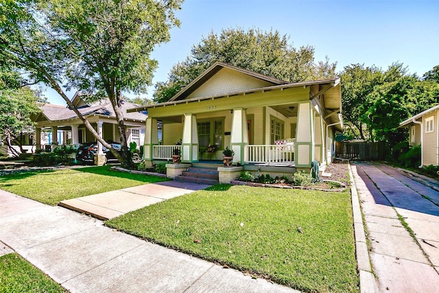 bungalow with covered porch and a front yard