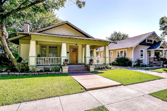 view of front of home featuring covered porch and a front yard