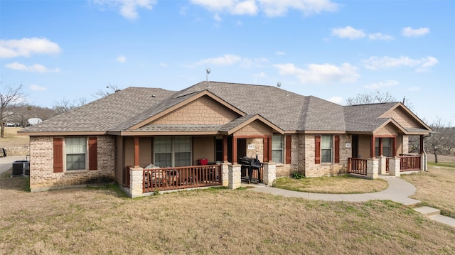 craftsman inspired home featuring a front yard, covered porch, and central air condition unit