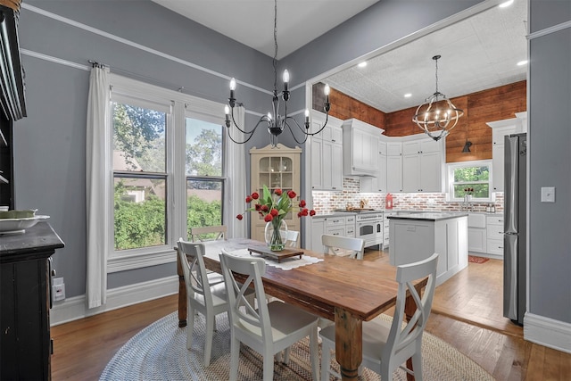 dining room featuring plenty of natural light, wood-type flooring, and a chandelier