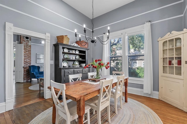 dining area featuring dark wood-type flooring and an inviting chandelier