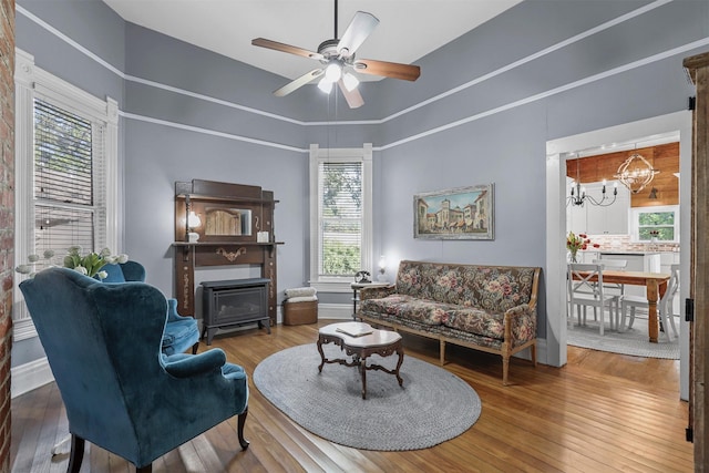 living room featuring plenty of natural light, ceiling fan with notable chandelier, and hardwood / wood-style flooring