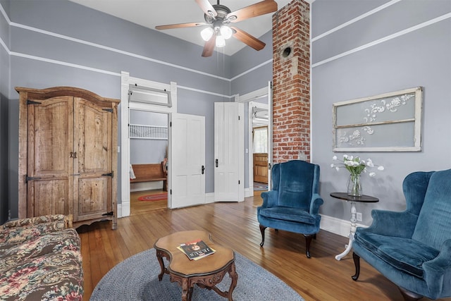 living area featuring ceiling fan and hardwood / wood-style flooring