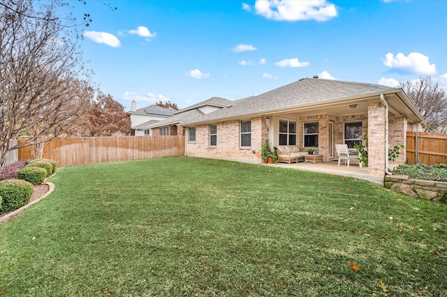 rear view of property with outdoor lounge area, a yard, and a patio