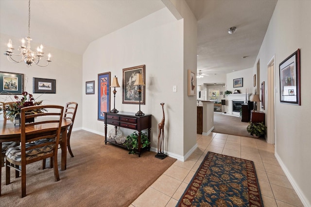 dining area featuring vaulted ceiling, light tile patterned floors, and ceiling fan with notable chandelier