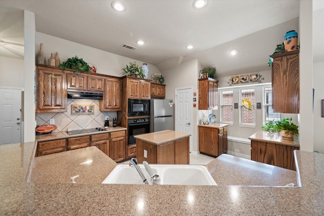 kitchen featuring tasteful backsplash, a kitchen island, black appliances, kitchen peninsula, and sink