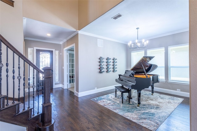 foyer entrance featuring a notable chandelier, ornamental molding, and dark hardwood / wood-style floors