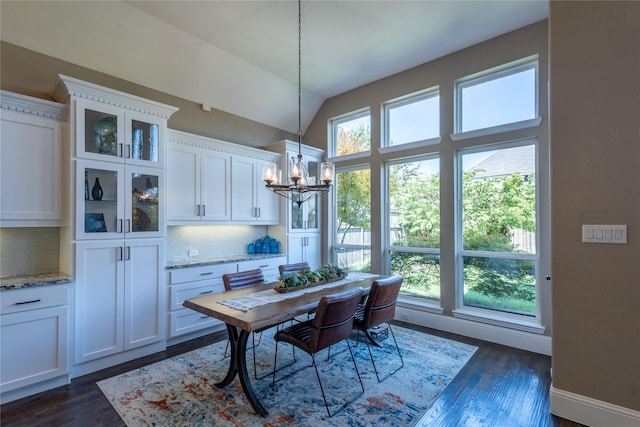 dining space featuring vaulted ceiling, dark wood-type flooring, and an inviting chandelier