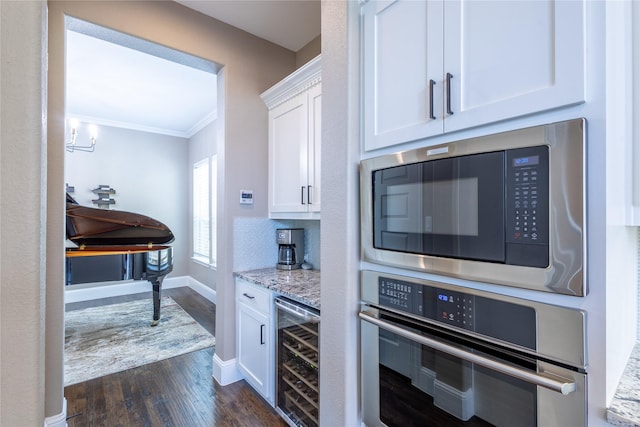 kitchen featuring light stone countertops, white cabinets, stainless steel appliances, and wine cooler