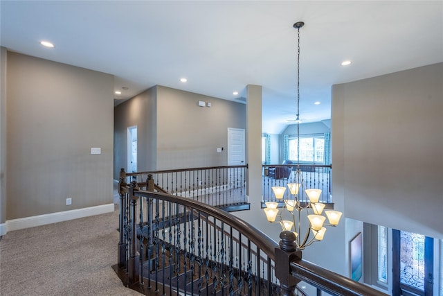 hall with a chandelier and carpet flooring