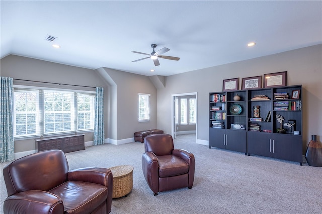 sitting room with ceiling fan, lofted ceiling, and light colored carpet