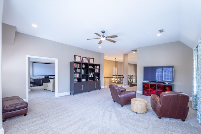 carpeted living room with ceiling fan and vaulted ceiling