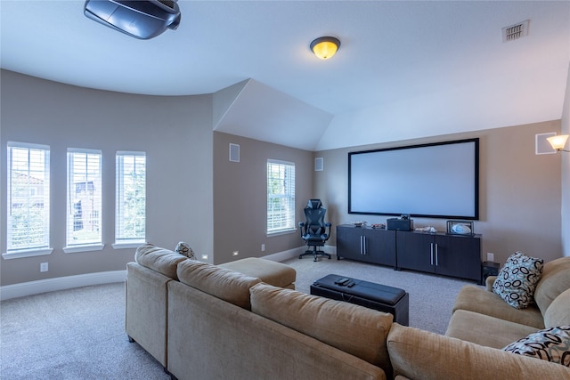 carpeted home theater with lofted ceiling and a healthy amount of sunlight