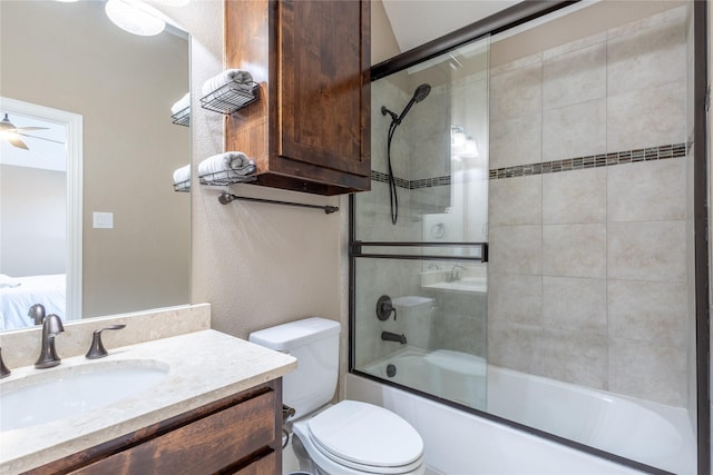 full bathroom featuring ceiling fan, toilet, vanity, and shower / bath combination with glass door