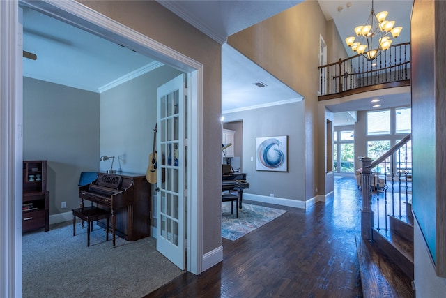 foyer entrance with a notable chandelier, dark hardwood / wood-style flooring, and crown molding