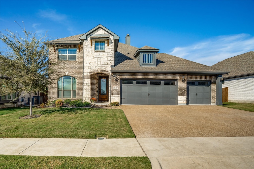 view of front of property with a front lawn, cooling unit, and a garage