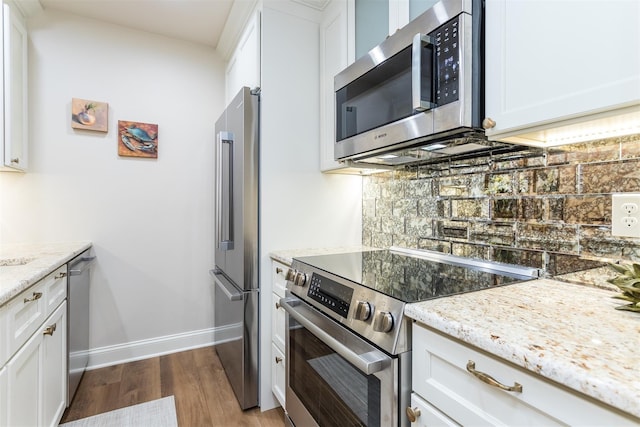 kitchen with light stone countertops, white cabinets, and appliances with stainless steel finishes