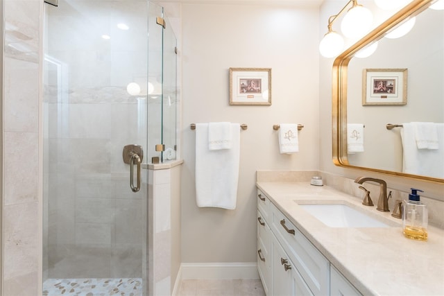 bathroom with a shower with shower door and vanity