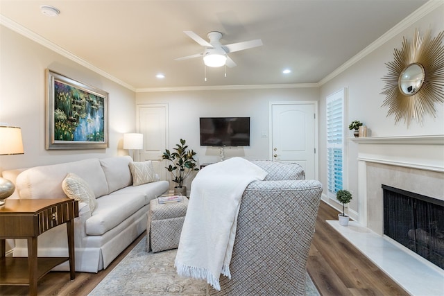 living room with ceiling fan, a fireplace, crown molding, and hardwood / wood-style flooring