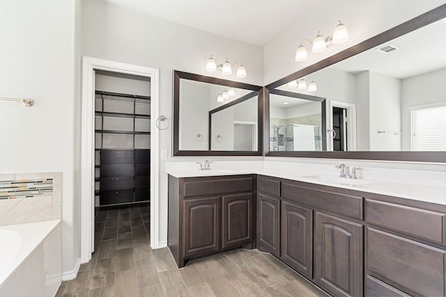 bathroom with vanity and shower with separate bathtub