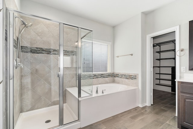 bathroom featuring separate shower and tub and vanity