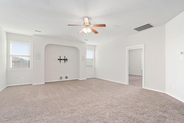 unfurnished room featuring carpet floors, ceiling fan, and a healthy amount of sunlight