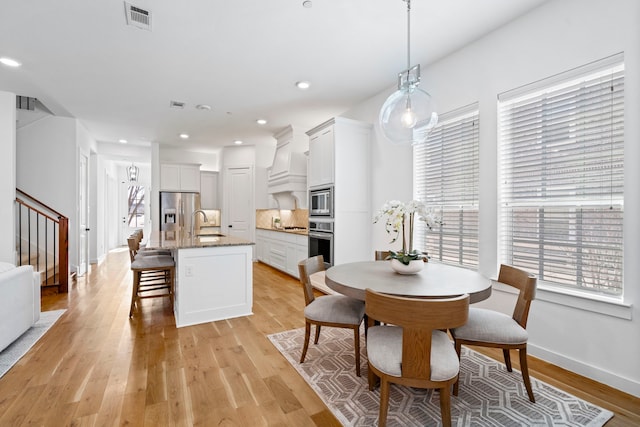 dining area featuring sink and light hardwood / wood-style flooring