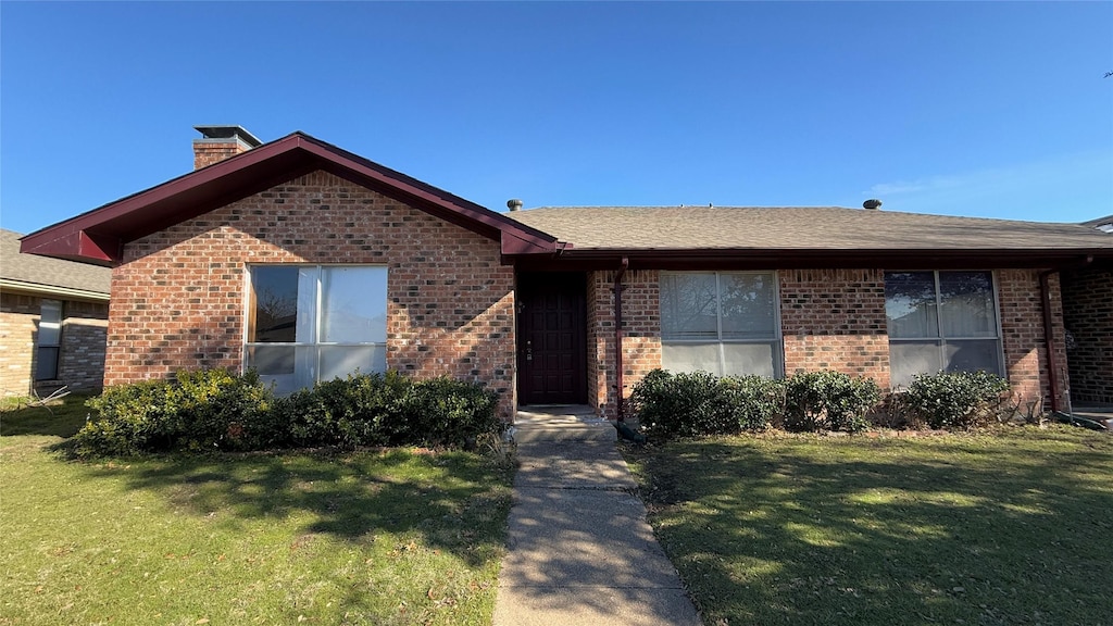 single story home featuring a front lawn