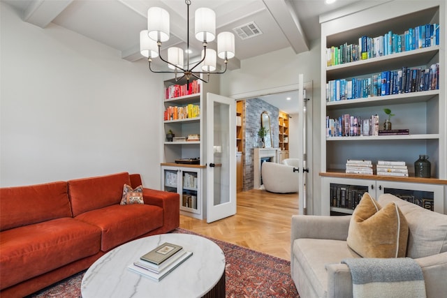 living room with a notable chandelier, beamed ceiling, and light parquet floors