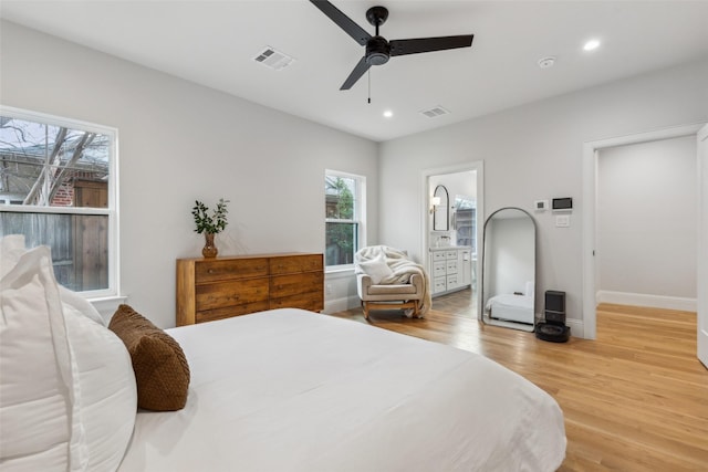 bedroom with ensuite bath, ceiling fan, and light hardwood / wood-style floors