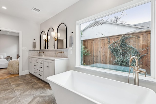 9736 Chiswell Rd, Dallas, TX 75238 - bathroom featuring recessed lighting, a sink, double vanity, visible vents, and a soaking tub