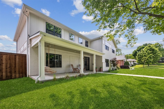 9736 Chiswell Rd, Dallas, TX 75238 - back of house with a patio, a lawn, board and batten siding, brick siding, and fence