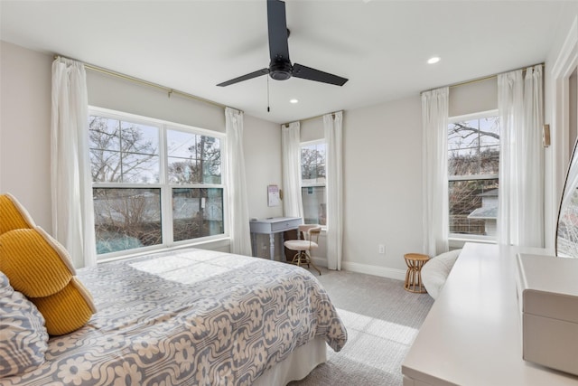 carpeted bedroom with ceiling fan and multiple windows