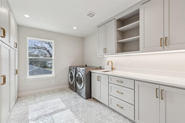 clothes washing area featuring sink, independent washer and dryer, and cabinets